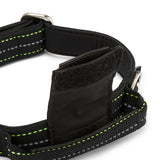 Black dog harness with reflective stripes on a white background